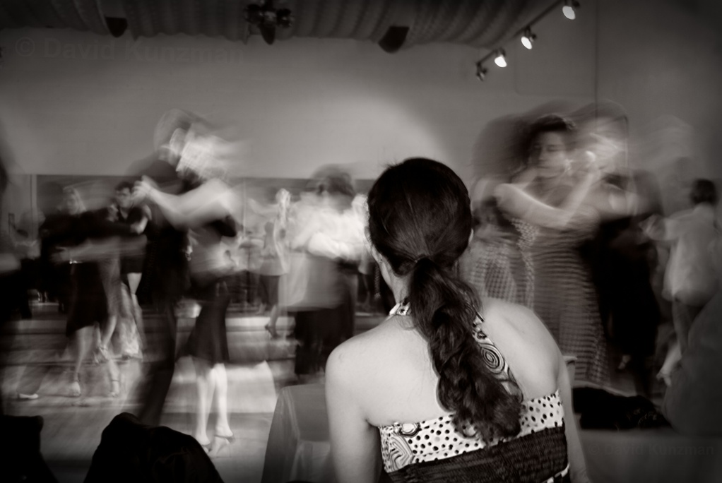 Long exposure photograph showing the movements of many Argentine Tango dancers as they move across the dance floor at a milonga in Atlanta, Georgia.